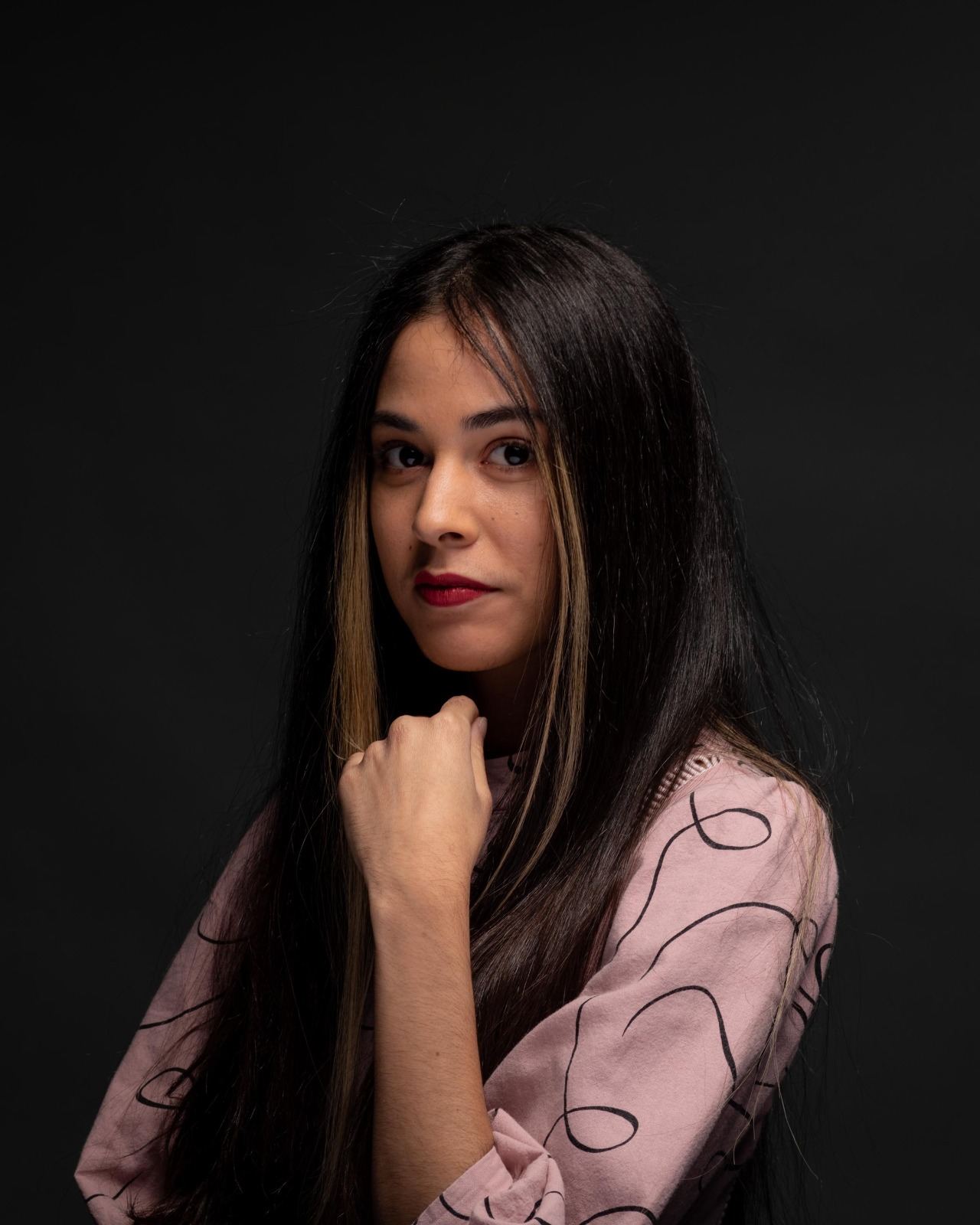 title Genesis photography- shows a woman with black hair and a pink shirt.